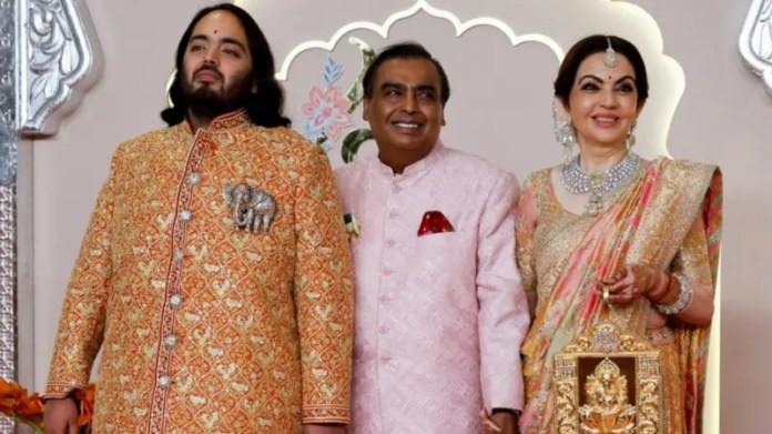 Neeta y Mukesh Ambani, con su hijo, el novio.