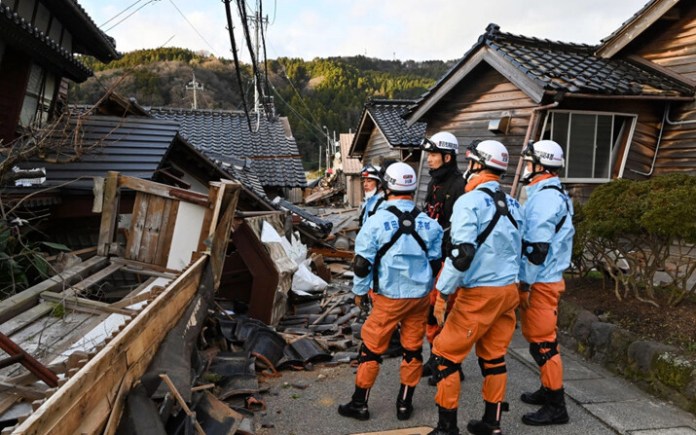 Bomberos inspeccionan casas de madera derrumbadas en Wajima, prefectura de Ishikawa, el 2 de enero de 2024, un día después de que un gran terremoto de magnitud 7.5 sacudiera la región de Noto en la prefectura de Ishikawa. (Kazuhiro Nogi/AFP vía Getty Images) Fuente: The Epoch Times en español